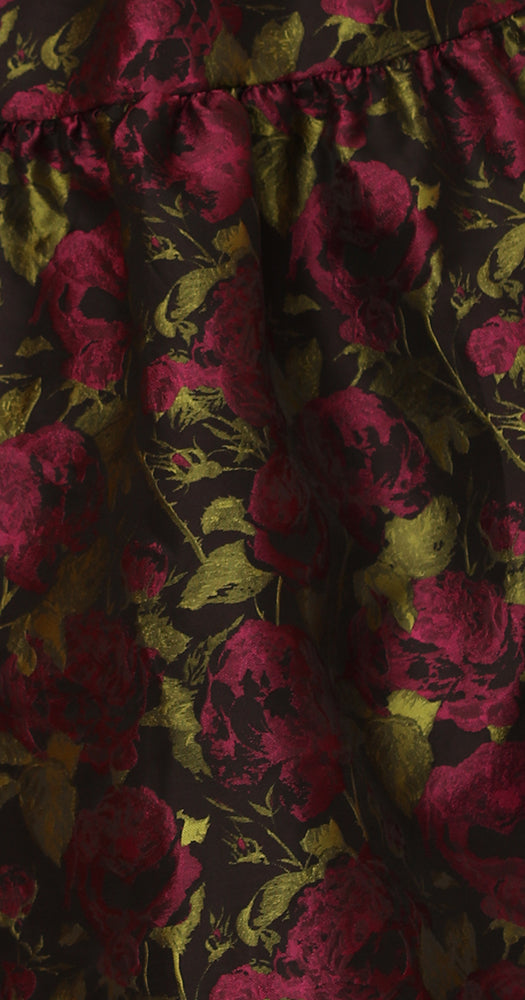 Close-up of TERRA floral patterned fabric with pink and gold flowers on a dark background