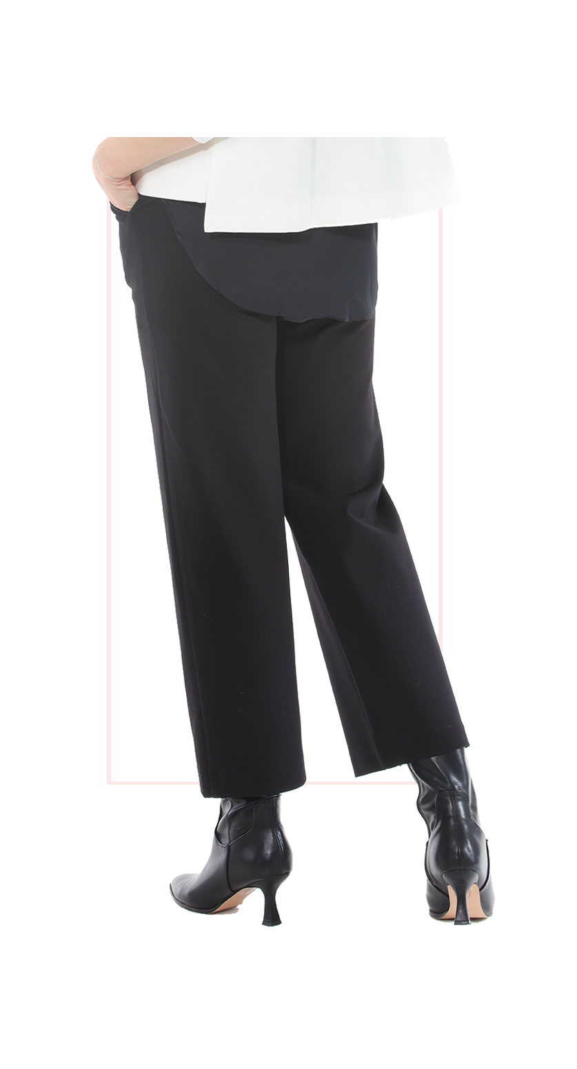 Woman wearing TERRA black high-rise wide-leg trousers with a flowing silhouette rear view