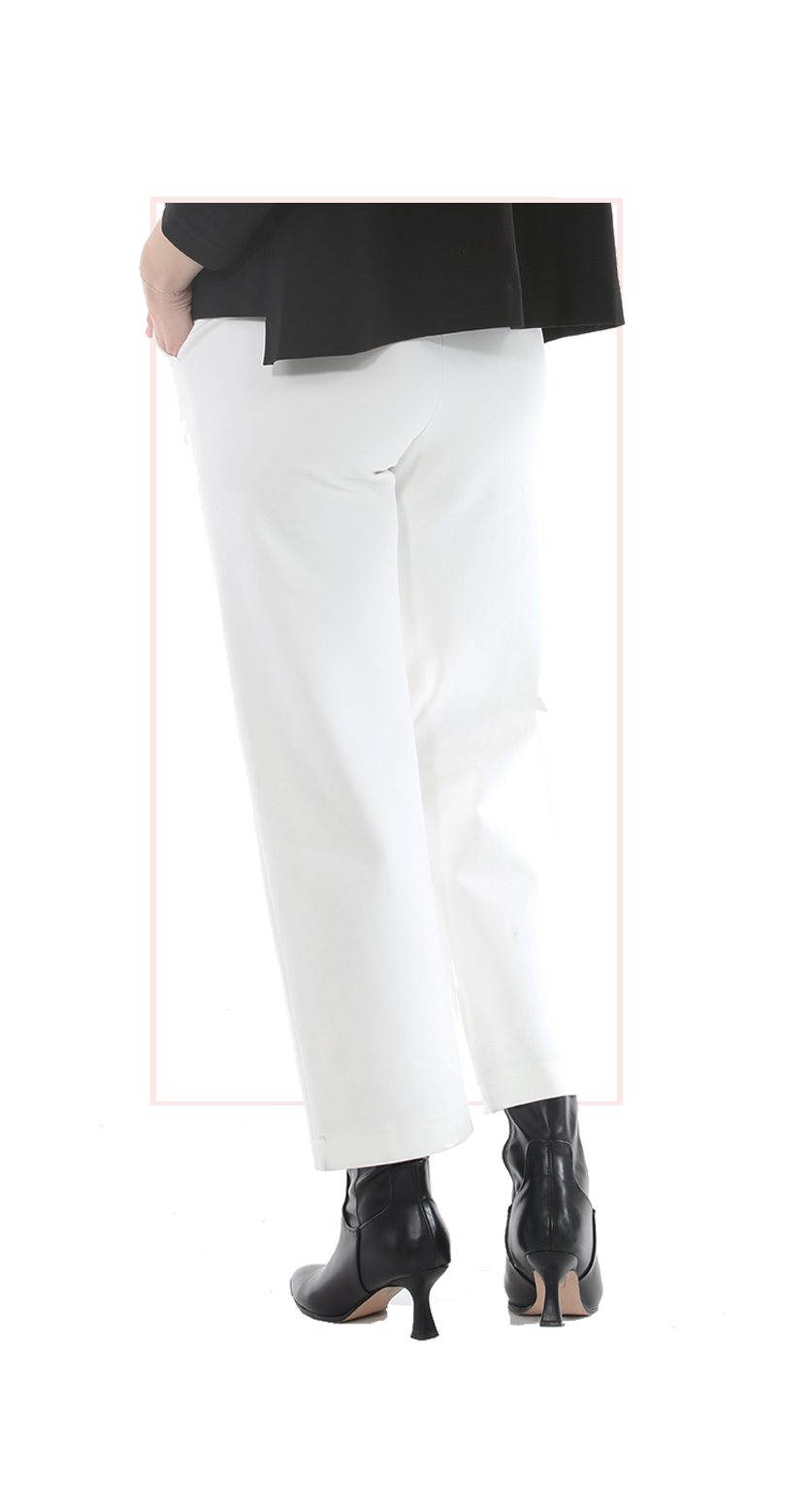 Woman wearing TERRA white high-rise wide-leg trousers with a flowing silhouette rear view