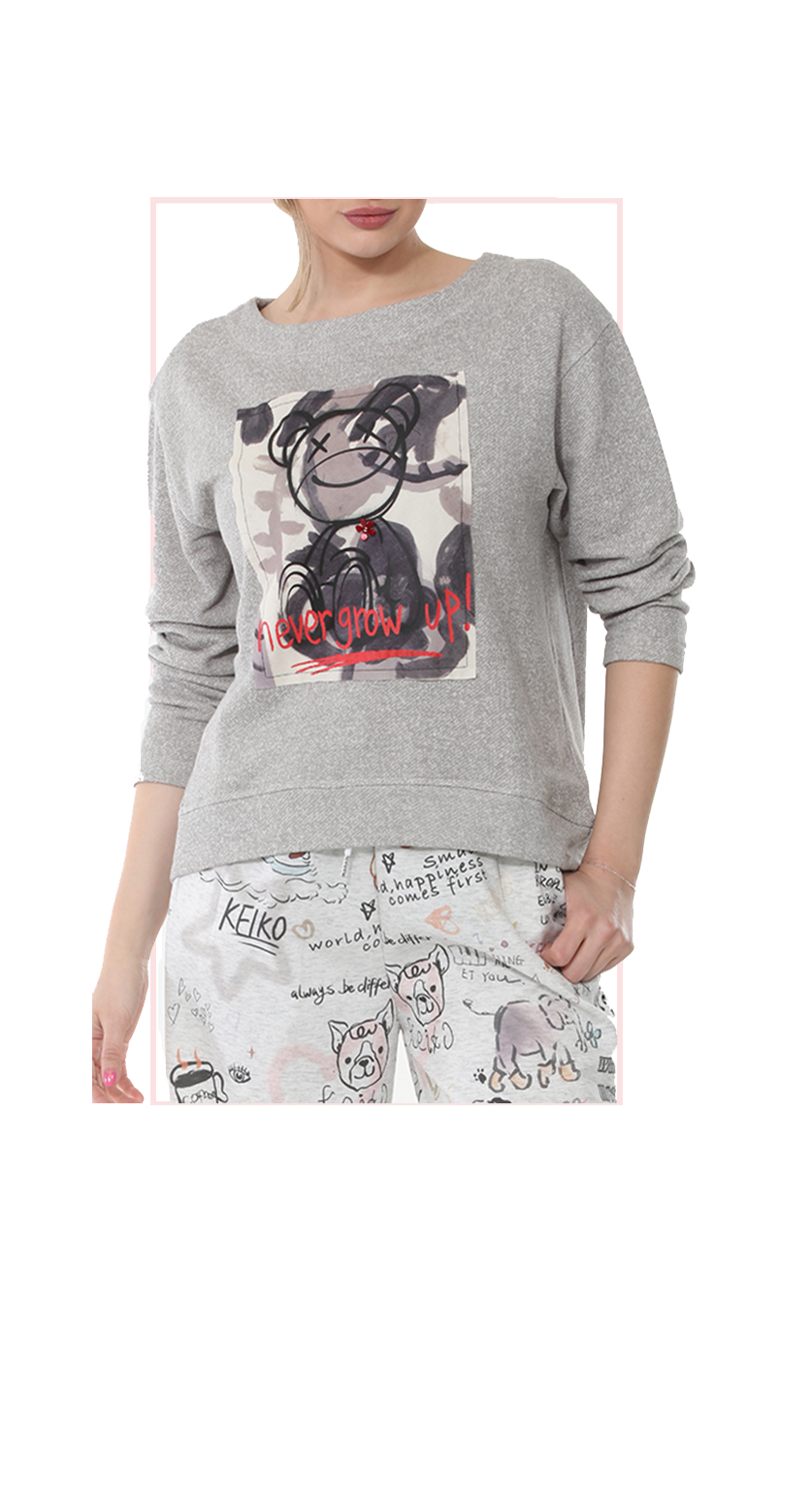 woman wearing gray sweatshirt with gray print pants on white background