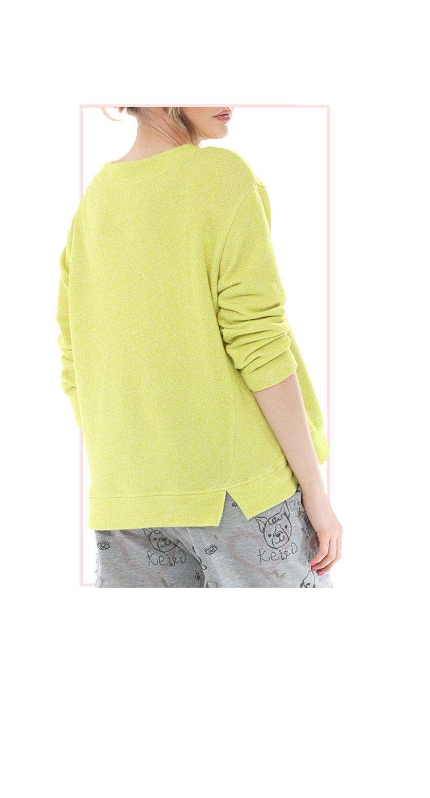 women wearing a golden kiwi colored sweater and gray pants on a white background