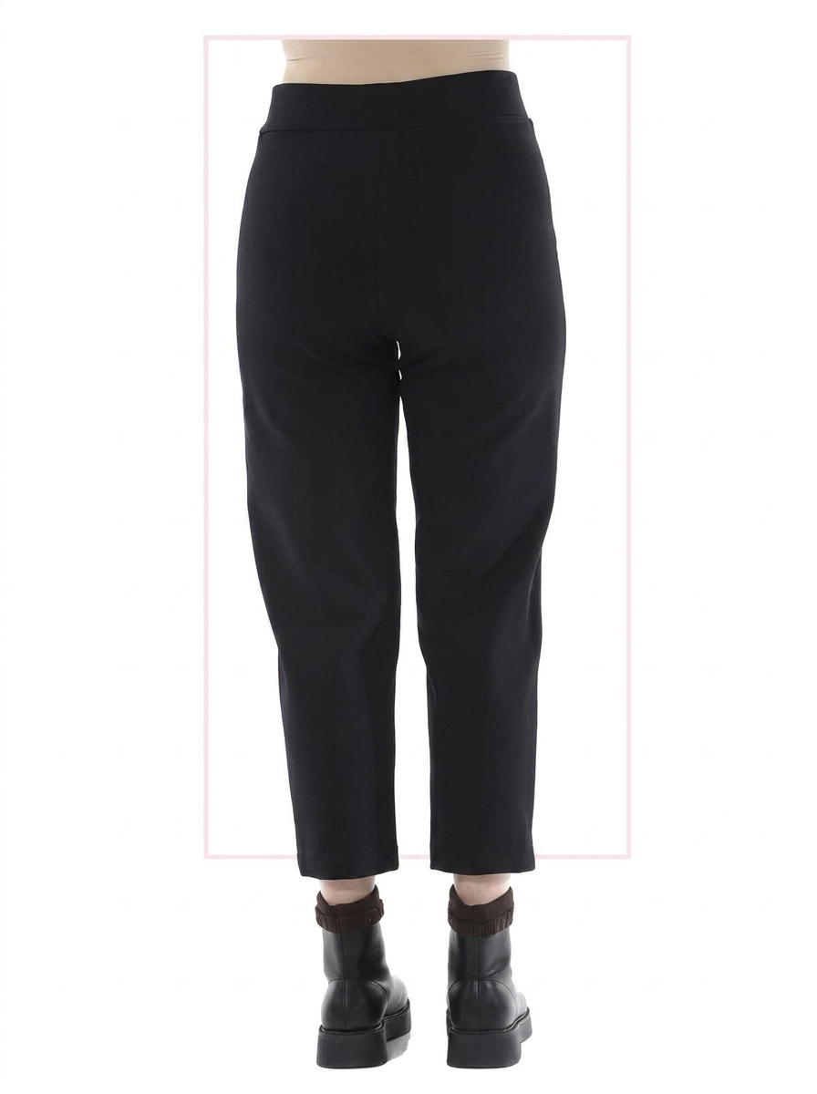 Black pants worn by a woman on a white background