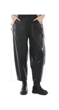 woman wearing black leather pants and boots on a white background