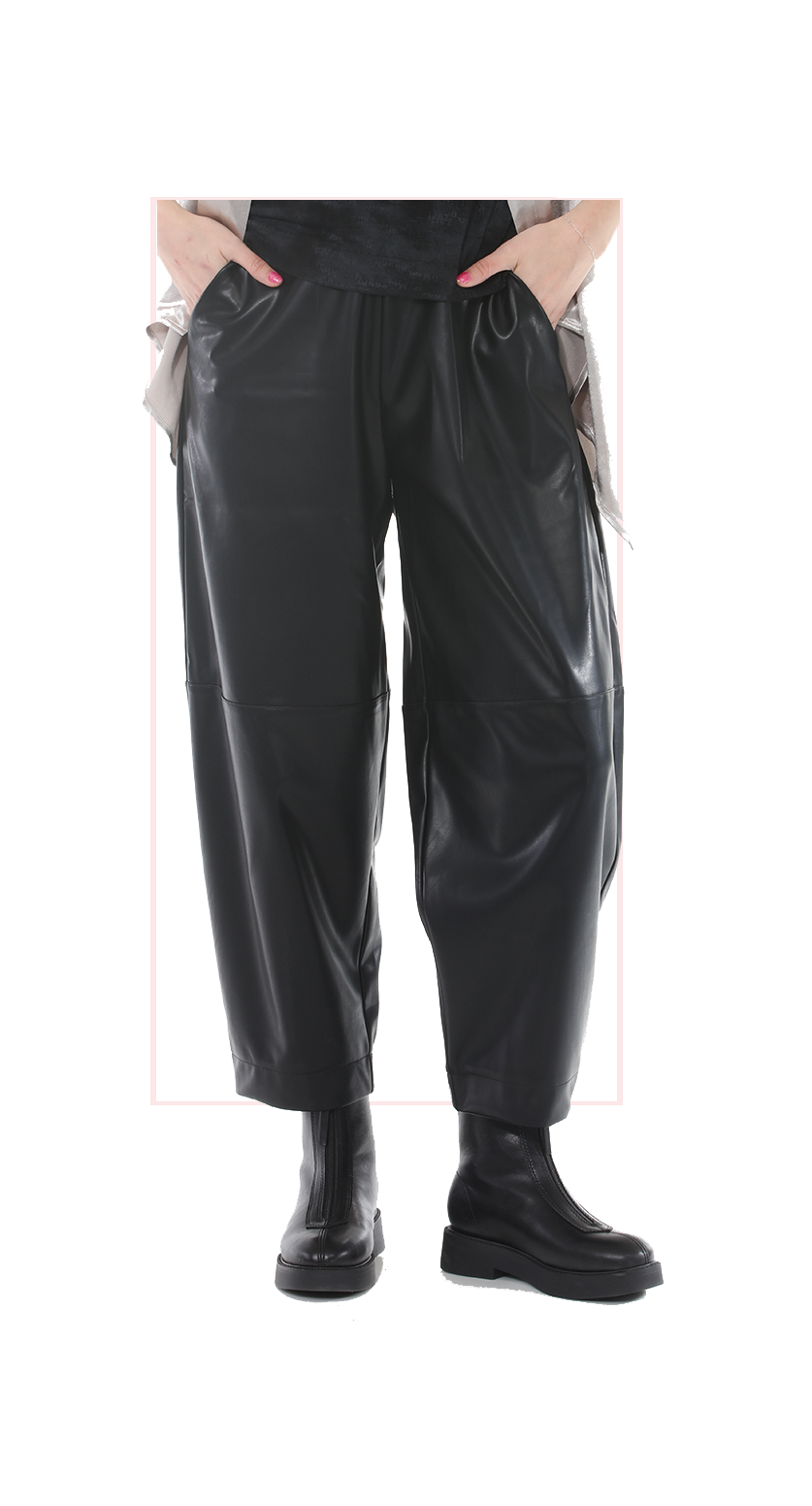 woman wearing black leather pants and boots on a white background