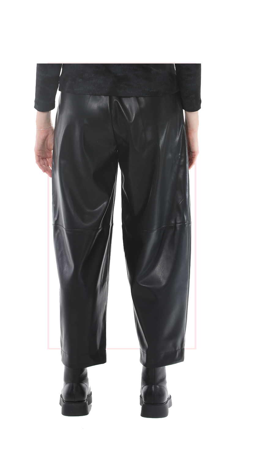 Black leather pants worn by a woman on a white background