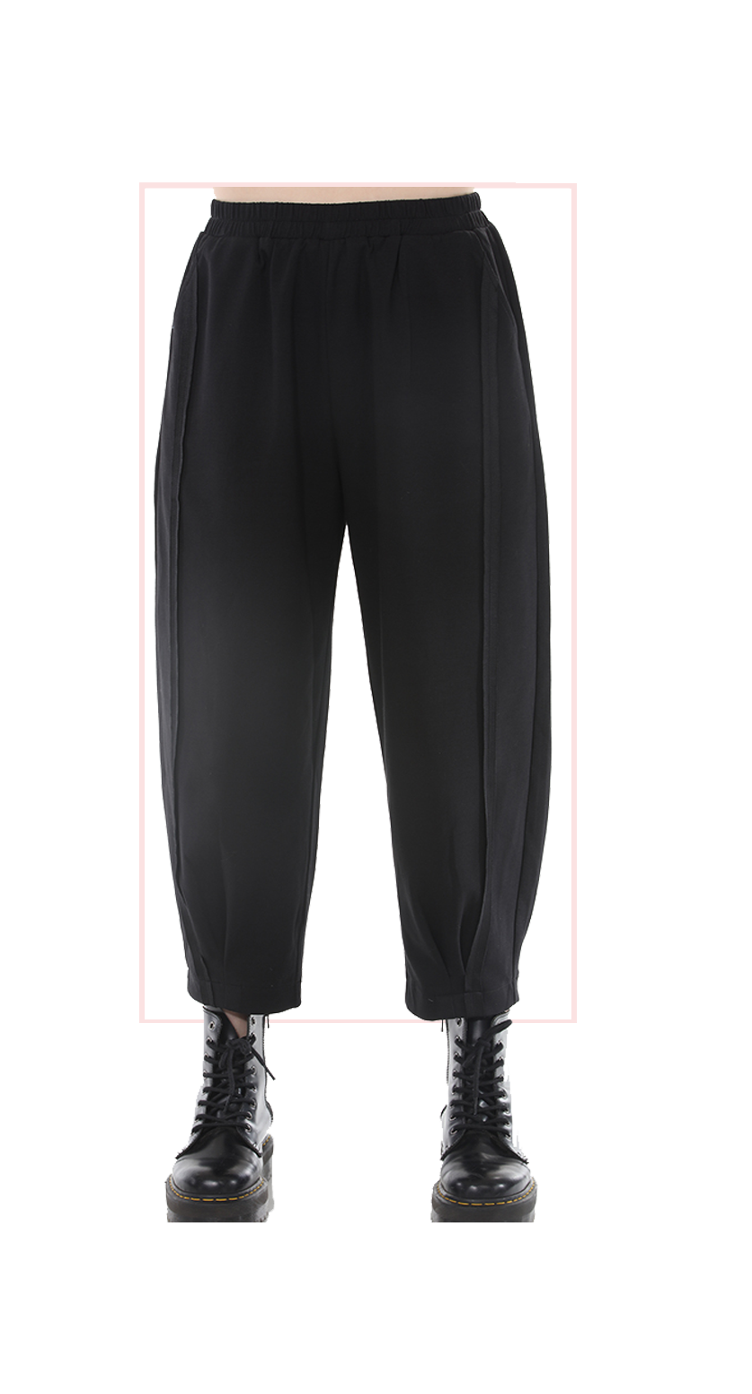 Black wide-leg pants worn by a woman on a white background