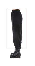 Black pants worn with black boots on a white background
