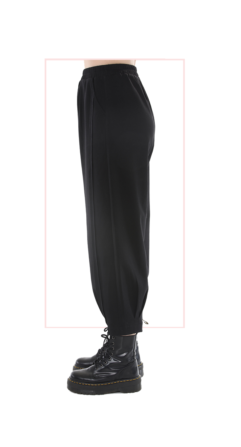 Black pants worn with black boots on a white background