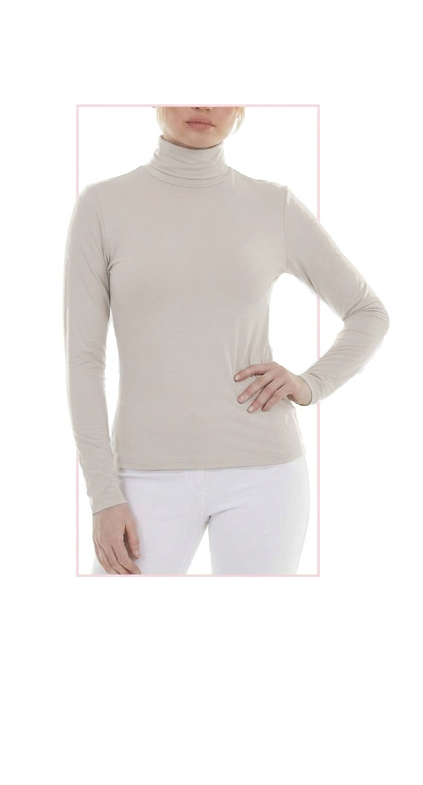 woman wearing a ivory turtleneck top and white pants on a white background