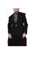 woman wearing a black blazer with a gold padlock charm on the front on a white background
